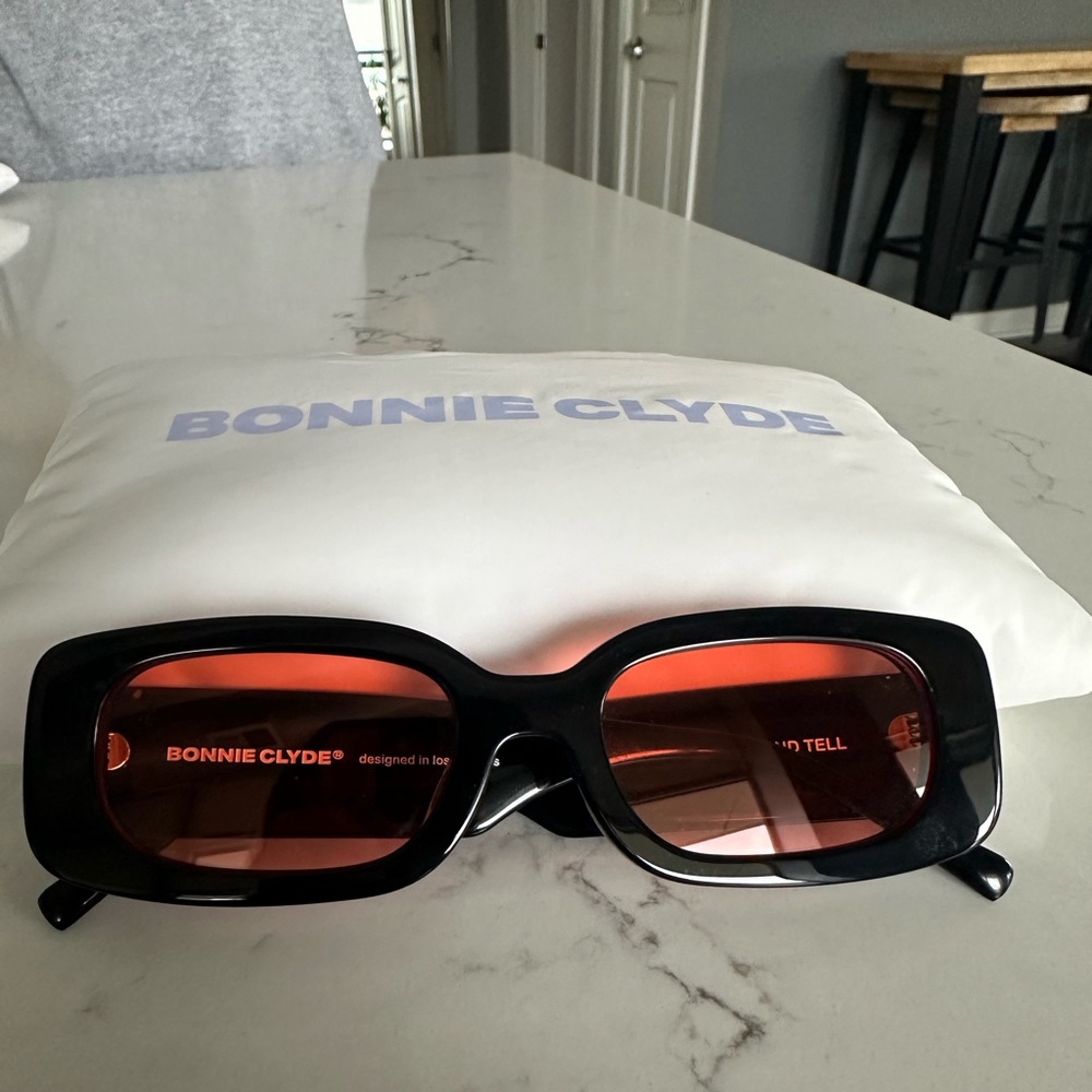 Bonnie Clyde Show and Tell Sunglasses. Black frame with red/orange lenses.